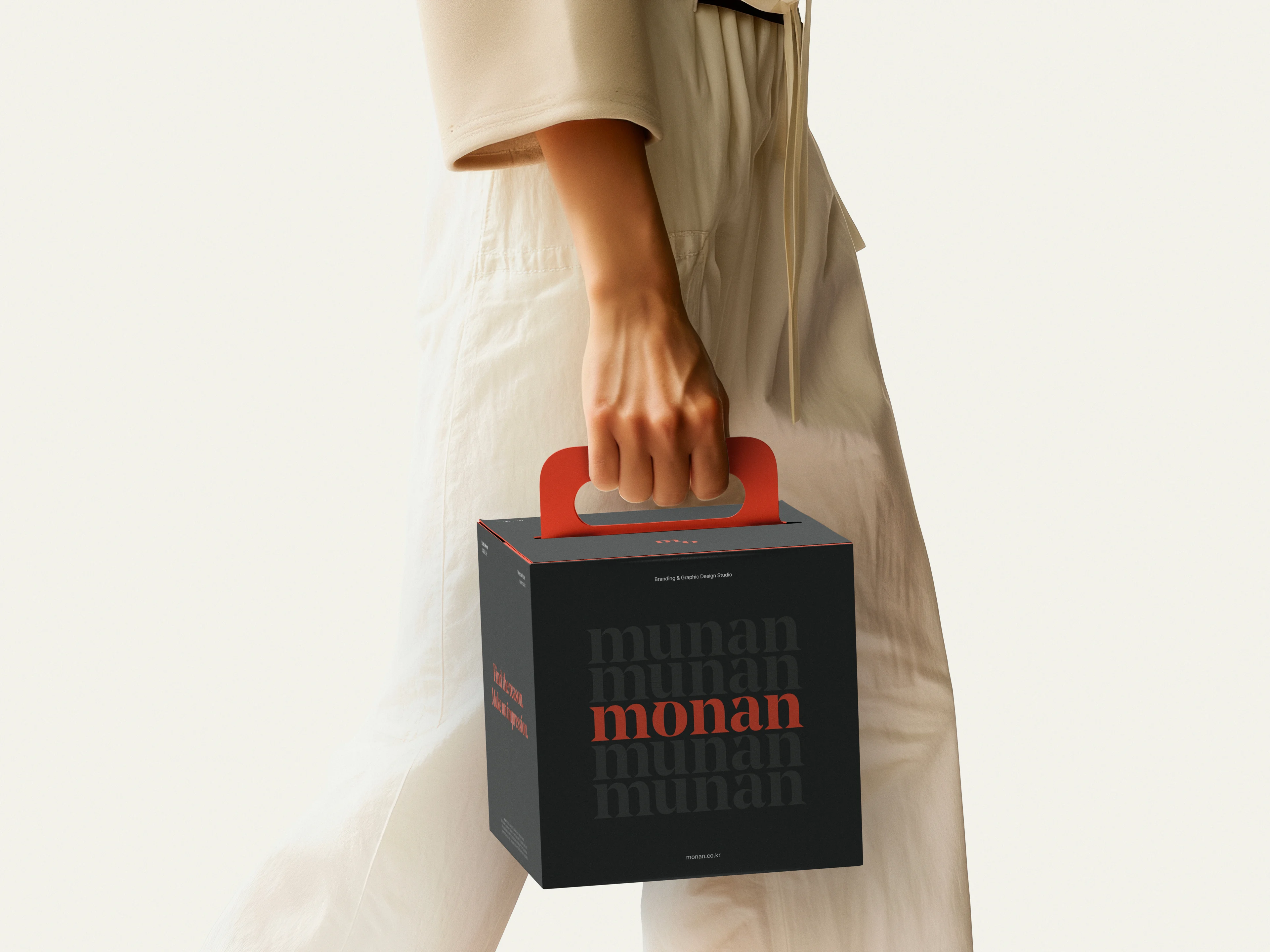 적색 손잡이가 달린 검은 monan 상자를 들고 걷는 사람의 손.