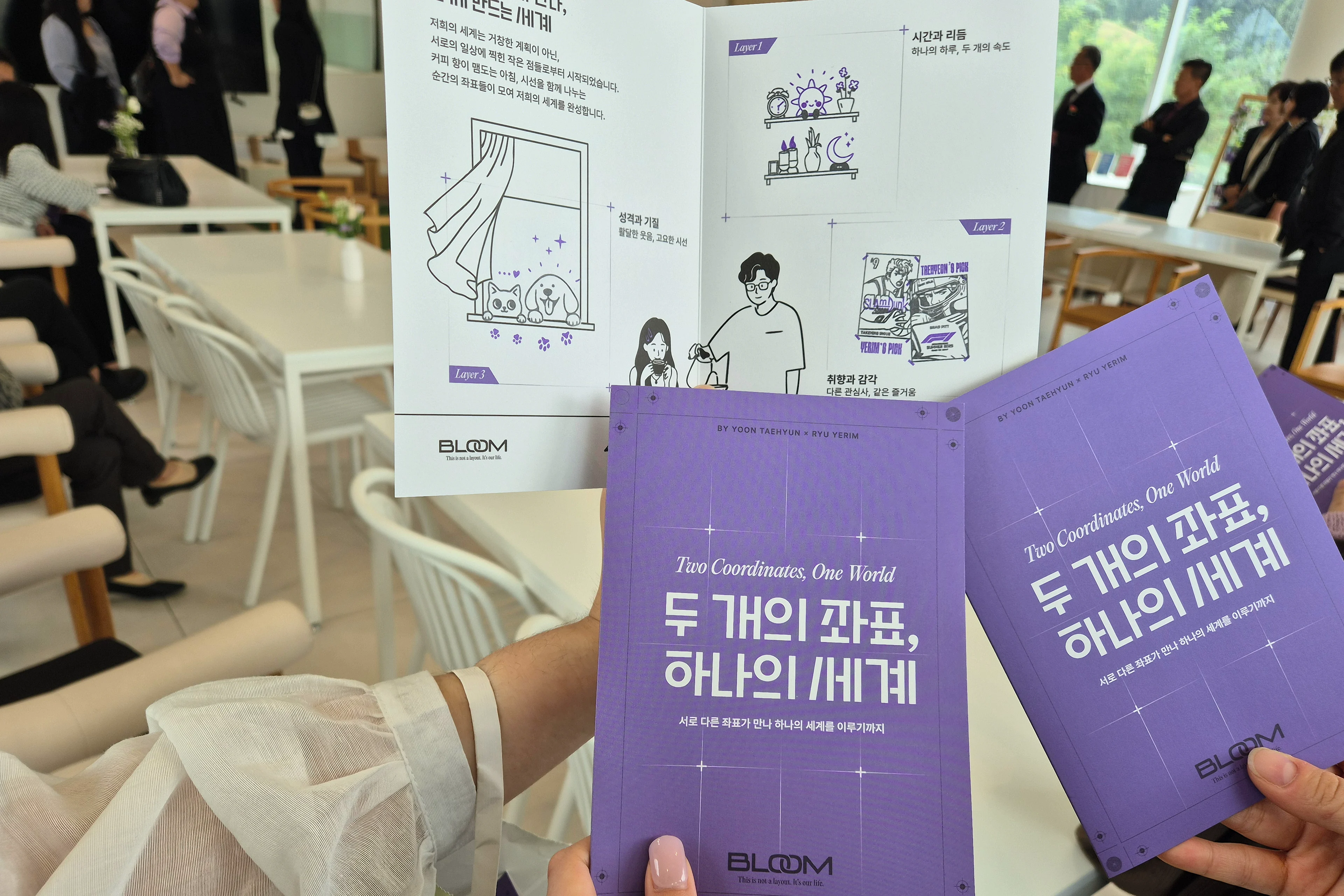 식장에서 하객들이 손에 든 협업자 가이드. 보라 표지 두 부와 Layer 1~3 칸에 강아지·고양이, 선반, 포스터 도장을 모두 찍은 안쪽 펼침면
